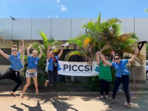 The PICCSI team hold up a banner and celebrate their work tackling cervical cancer